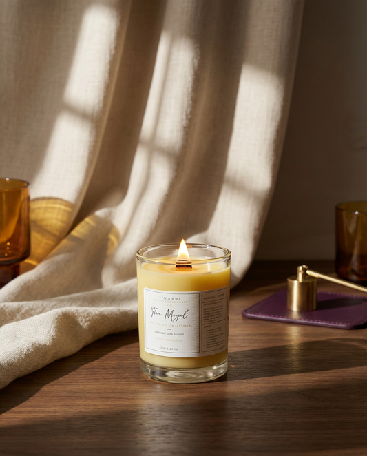 Candle in a glass jar with a label on a wooden surface, draped with a cloth.